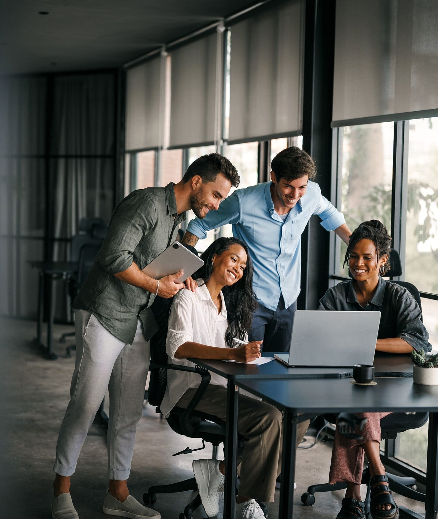 Team collaborating around laptop during meeting