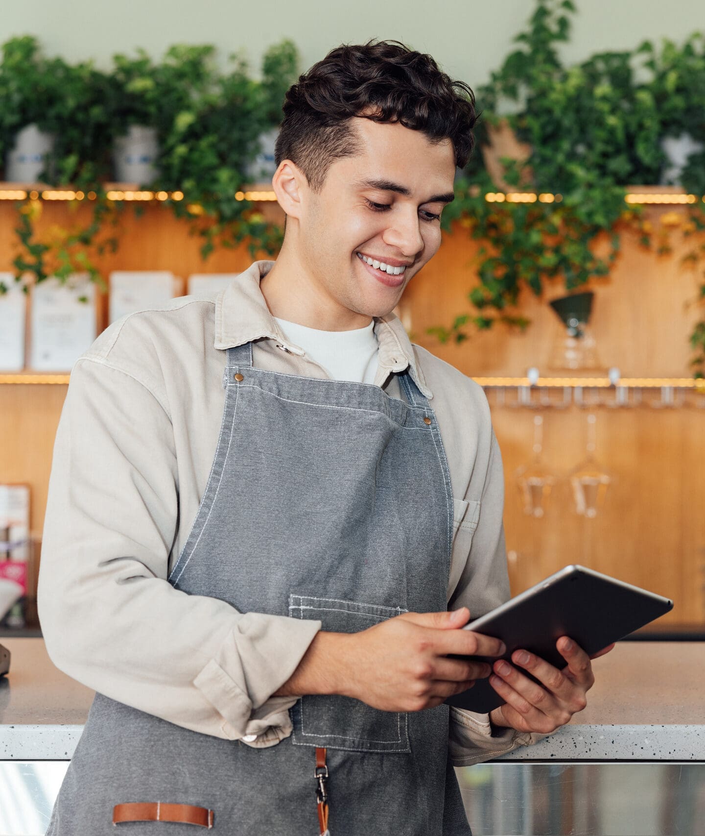 Merchant using tablet behind store counter