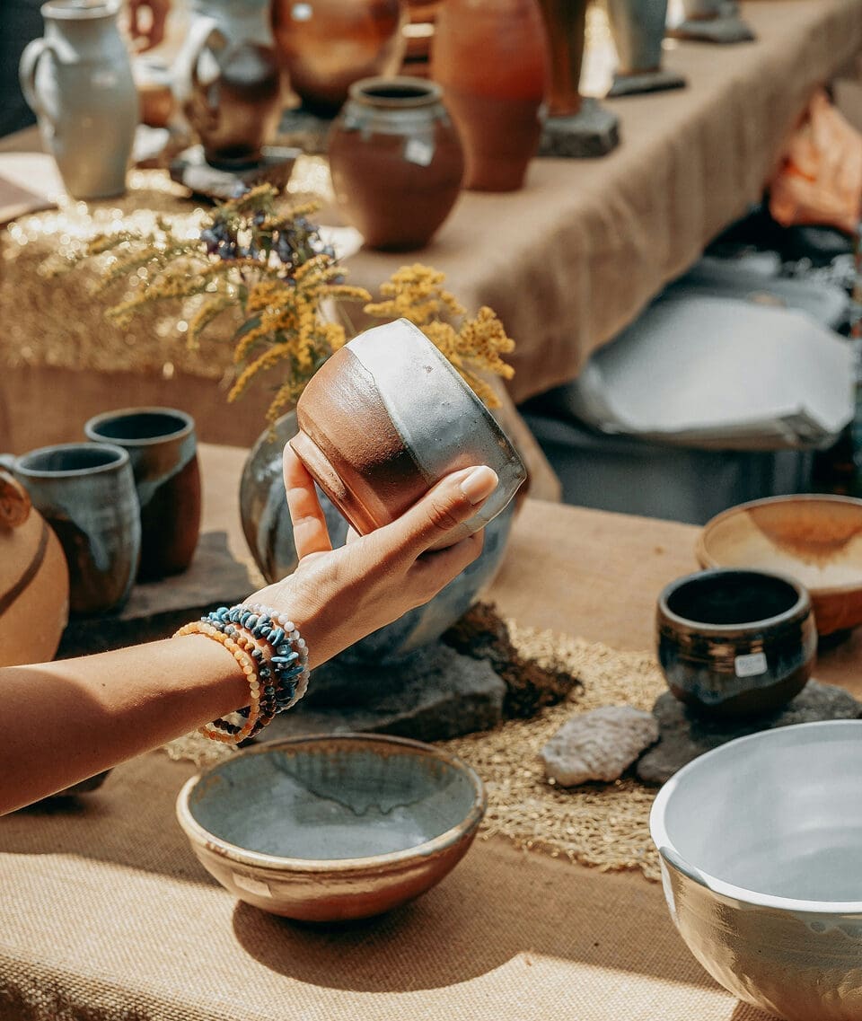 Artisan arranging handmade pottery