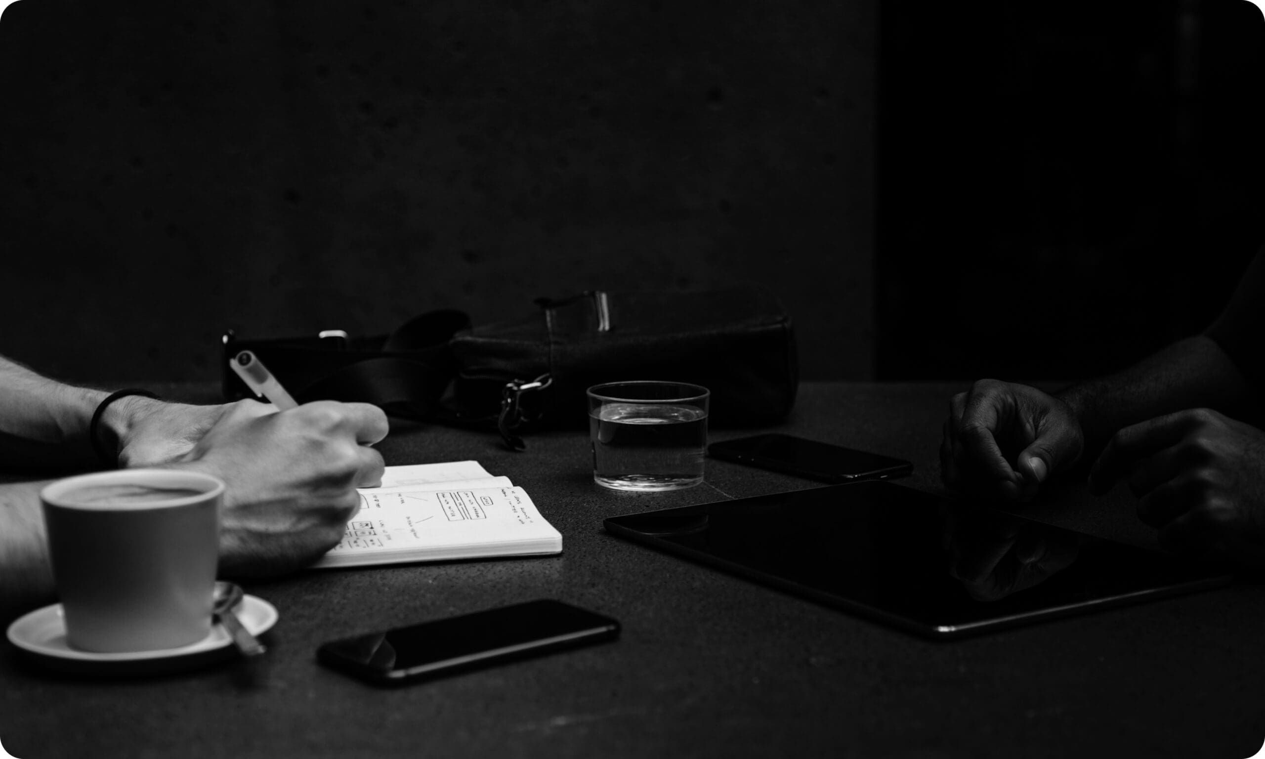 Person writing notes in notebook on table