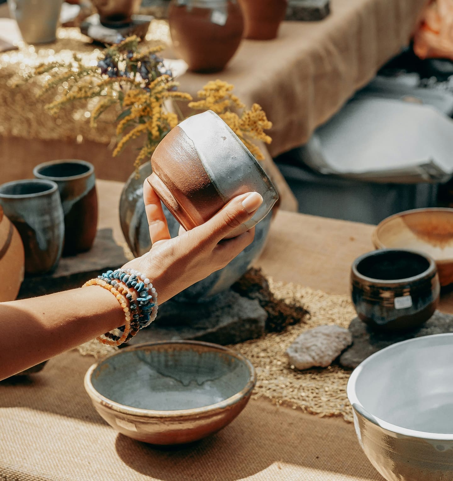 Artisan arranging handmade pottery